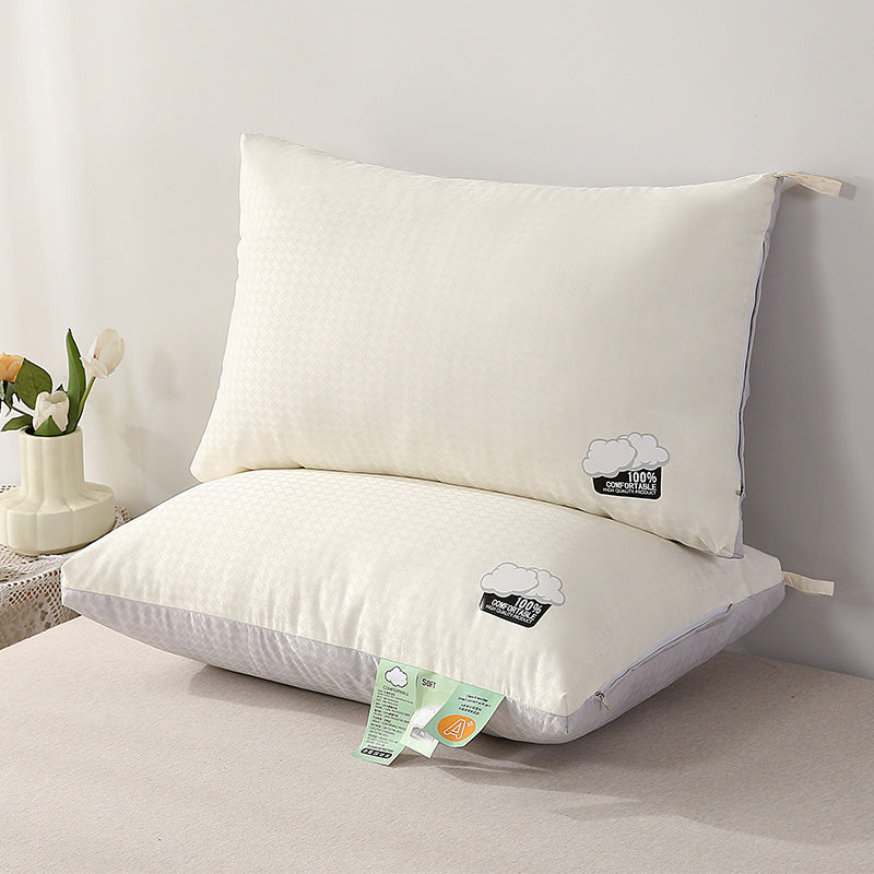 Two white pillows with labels on a bed against a light gray wall.